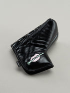 Black quilted leather golf headcover with small icon of embroidered lips clutching a golf tee.